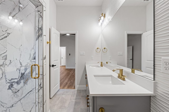 bathroom with a shower with shower door and vanity