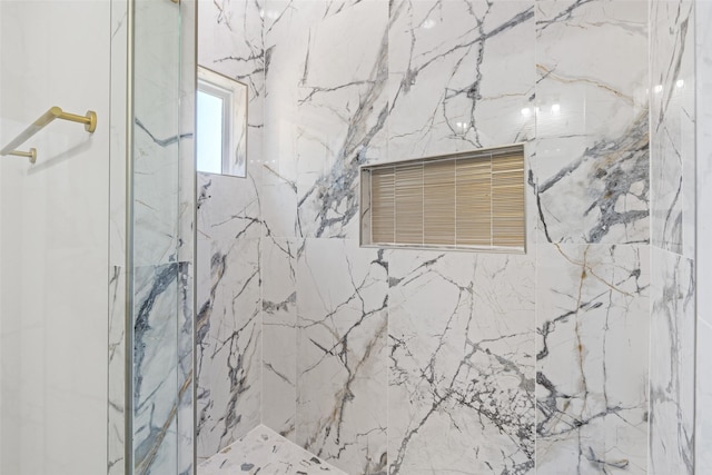 interior details featuring tiled shower