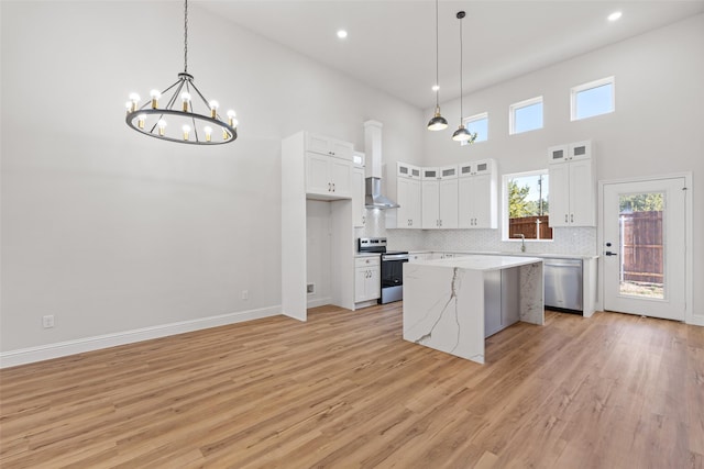 kitchen featuring pendant lighting, white cabinets, a center island, and stainless steel appliances