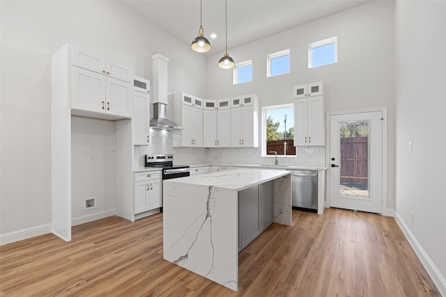 kitchen featuring light stone countertops, white cabinets, appliances with stainless steel finishes, and a center island