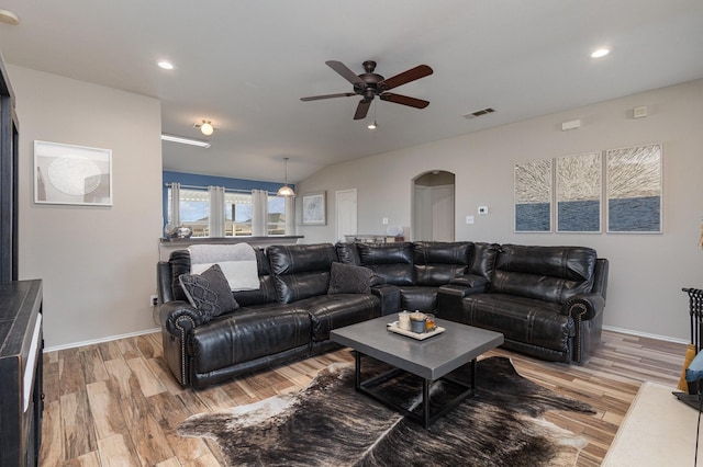 living room featuring ceiling fan, light wood-type flooring, and lofted ceiling