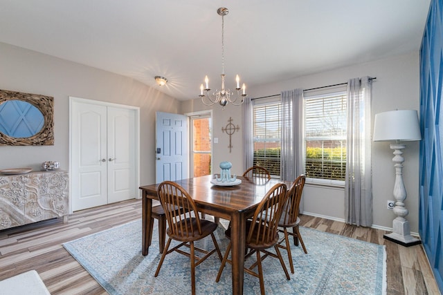 dining space with a chandelier and light hardwood / wood-style flooring