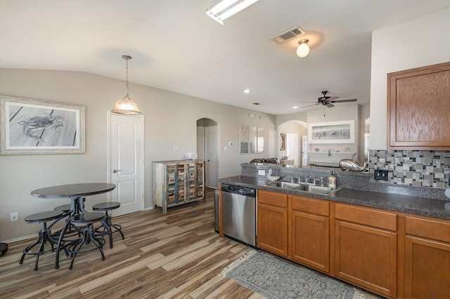 kitchen featuring dark hardwood / wood-style floors, backsplash, dishwasher, pendant lighting, and sink