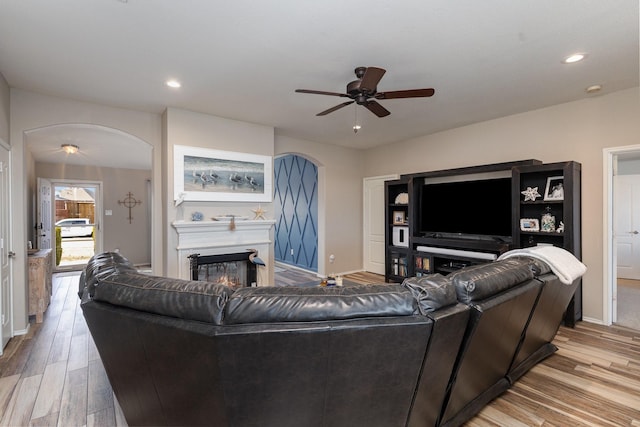 living room with ceiling fan and light hardwood / wood-style flooring