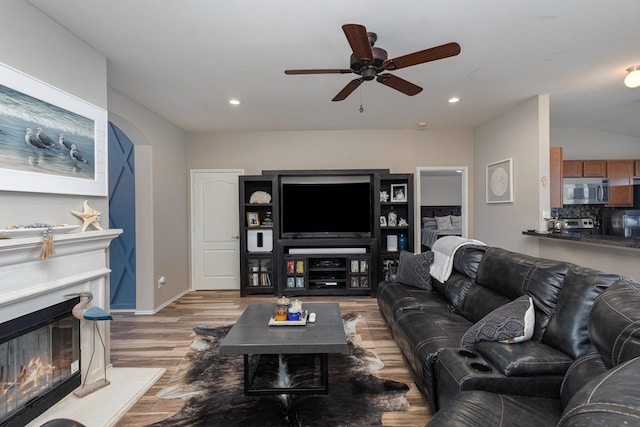 living room with ceiling fan and light hardwood / wood-style flooring