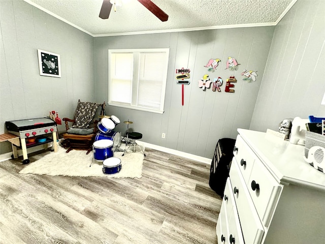 interior space featuring a textured ceiling, ornamental molding, and light hardwood / wood-style floors