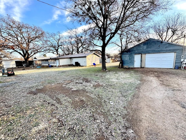 view of yard featuring a garage and an outbuilding