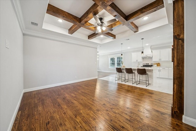 living room with beamed ceiling, ceiling fan, ornamental molding, hardwood / wood-style flooring, and coffered ceiling