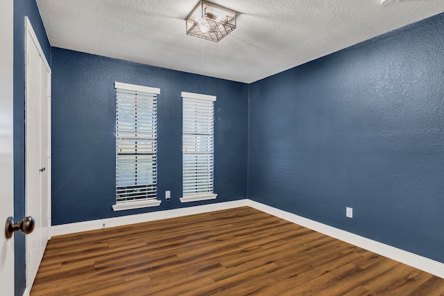 spare room featuring a textured ceiling and hardwood / wood-style flooring