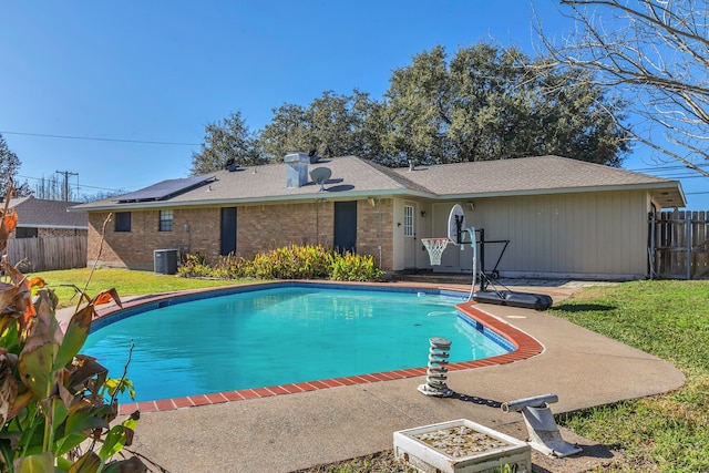 view of pool with cooling unit and a yard