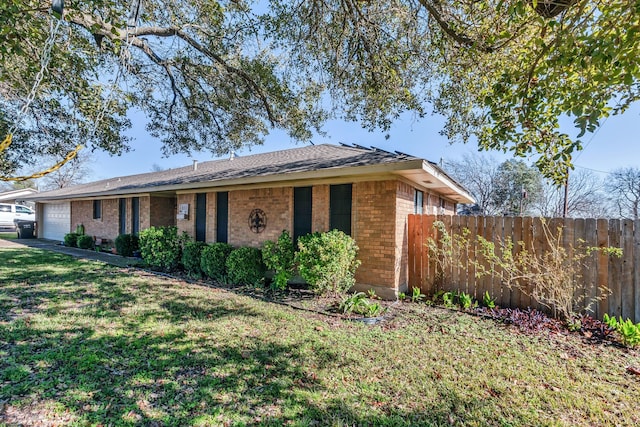 ranch-style home featuring a front lawn and a garage