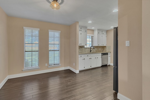 kitchen featuring tasteful backsplash, dishwasher, wood-type flooring, white cabinets, and sink