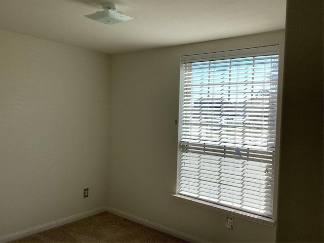 empty room featuring carpet flooring and baseboards