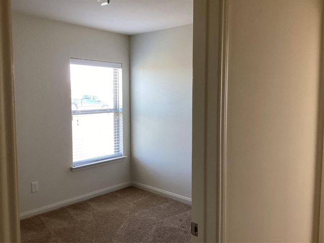 carpeted spare room with baseboards