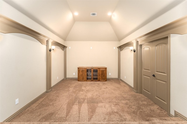 interior space with light carpet and vaulted ceiling