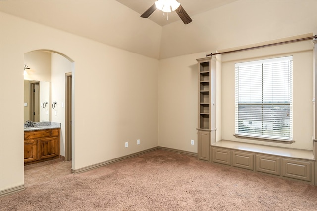 spare room featuring ceiling fan, light colored carpet, and lofted ceiling