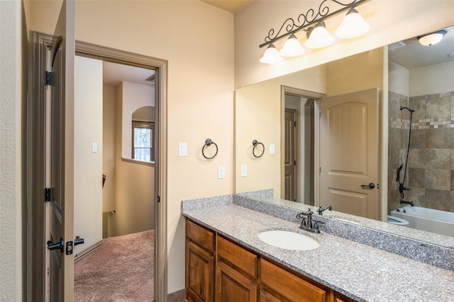 bathroom with tiled shower / bath and vanity