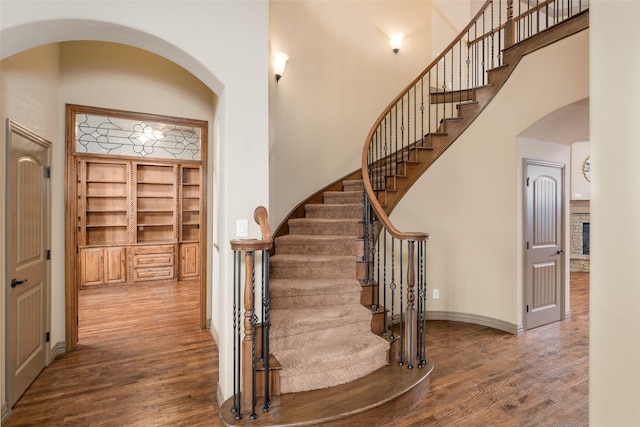 stairway featuring hardwood / wood-style floors and built in shelves