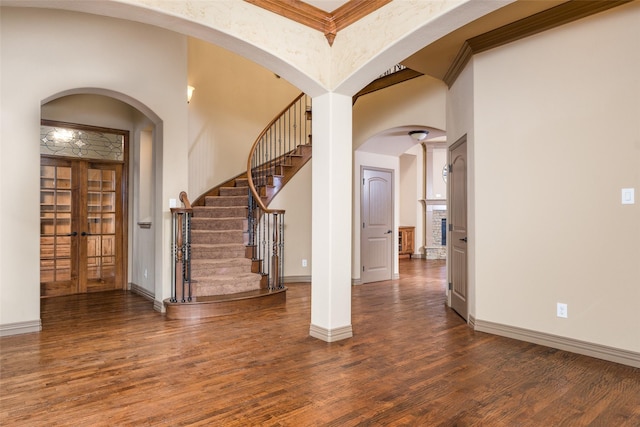 foyer featuring dark wood-type flooring and crown molding