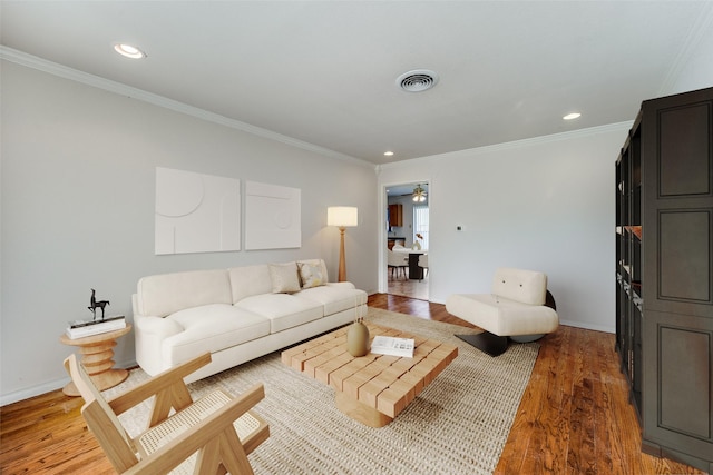 living room with crown molding and hardwood / wood-style floors