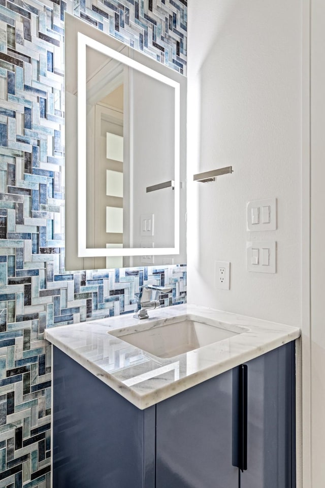 kitchen featuring light stone countertops, sink, and tasteful backsplash