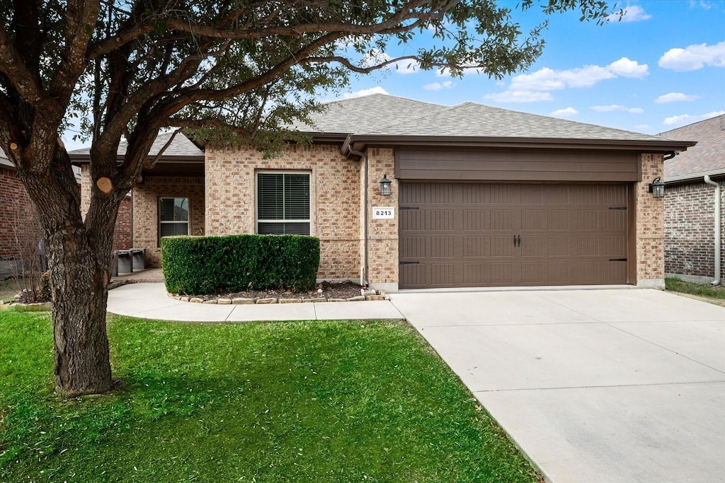 ranch-style house with a garage and a front lawn