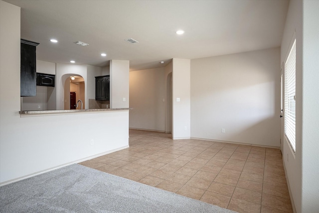 unfurnished living room with sink and light tile patterned floors