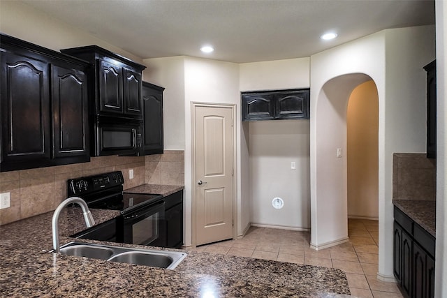 kitchen with black appliances, dark stone counters, decorative backsplash, sink, and light tile patterned floors