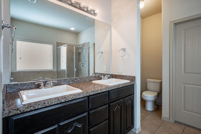 bathroom featuring toilet, tile patterned flooring, a shower with shower door, and vanity