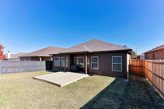 rear view of property featuring a lawn and a deck