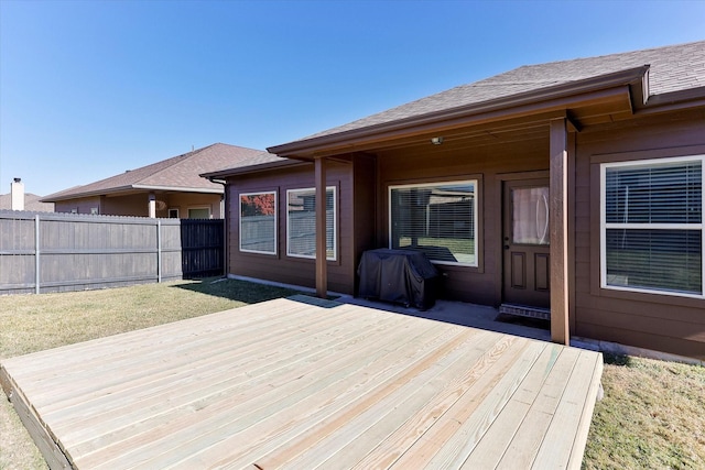 wooden deck with a lawn and area for grilling