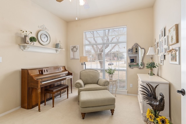 living area with light carpet, a healthy amount of sunlight, and ceiling fan