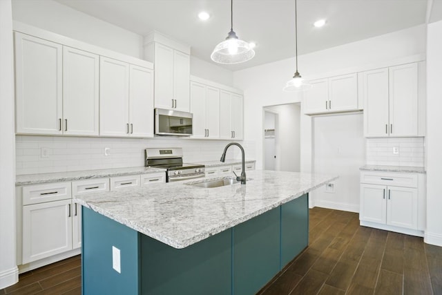 kitchen with decorative light fixtures, sink, stainless steel appliances, and white cabinetry