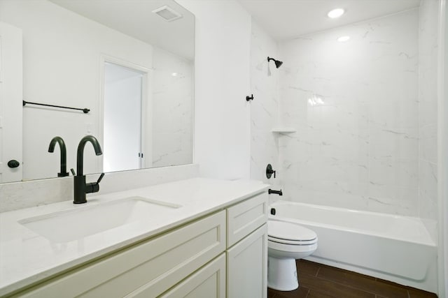 full bathroom featuring toilet, tiled shower / bath, and vanity