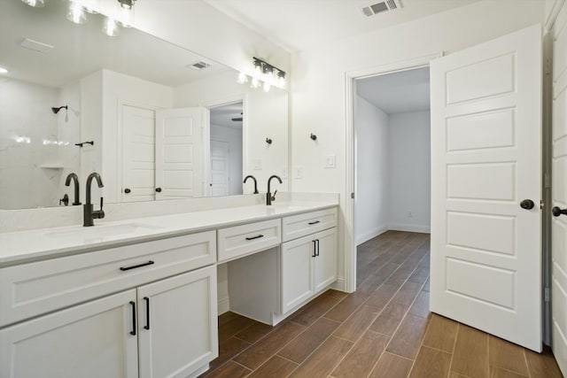 bathroom featuring a shower and vanity