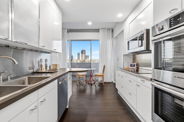 kitchen featuring white cabinets, dark hardwood / wood-style flooring, sink, and stainless steel appliances