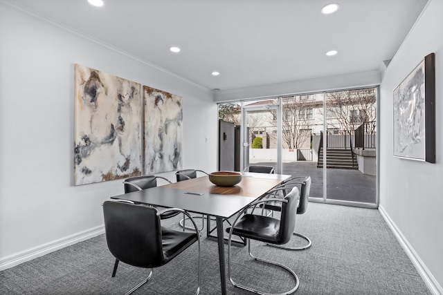 carpeted dining room featuring crown molding