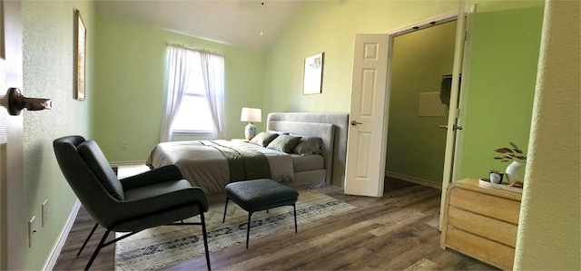 bedroom featuring lofted ceiling and dark hardwood / wood-style floors