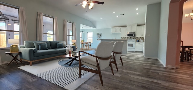 living room featuring dark wood-type flooring, lofted ceiling, and ceiling fan with notable chandelier