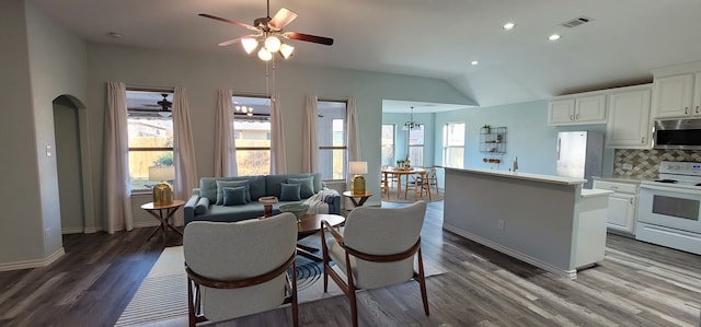 living room featuring hardwood / wood-style flooring, vaulted ceiling, and ceiling fan with notable chandelier