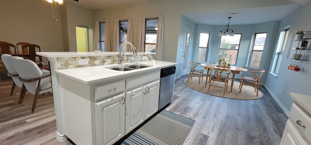 kitchen featuring sink, white cabinetry, hanging light fixtures, tasteful backsplash, and stainless steel dishwasher