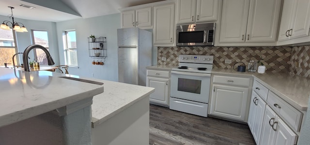 kitchen with white cabinetry, decorative backsplash, stainless steel appliances, and hanging light fixtures