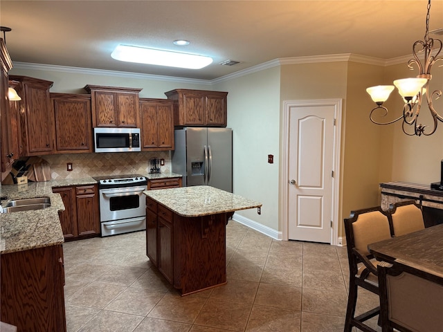 kitchen featuring a center island, crown molding, tasteful backsplash, visible vents, and appliances with stainless steel finishes