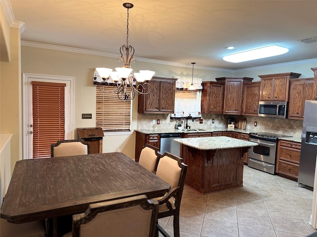 kitchen with stainless steel appliances, tasteful backsplash, visible vents, a kitchen island, and a sink