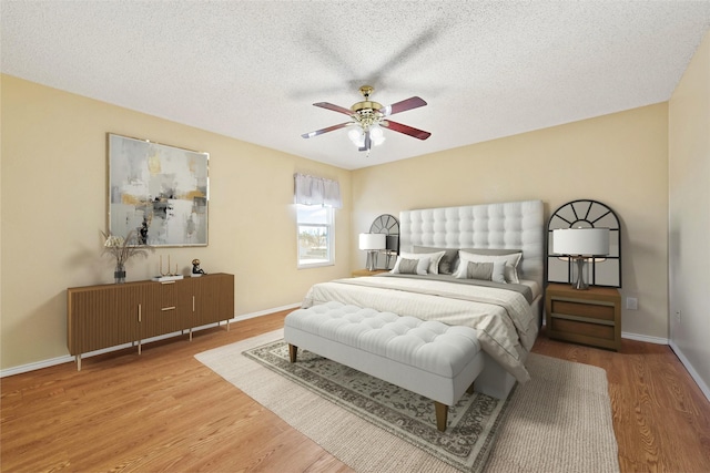 bedroom with wood-type flooring, a textured ceiling, and ceiling fan