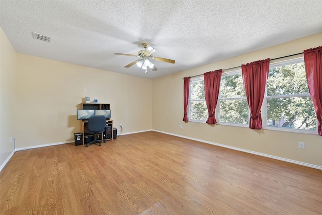 unfurnished office featuring ceiling fan, a textured ceiling, and light hardwood / wood-style flooring