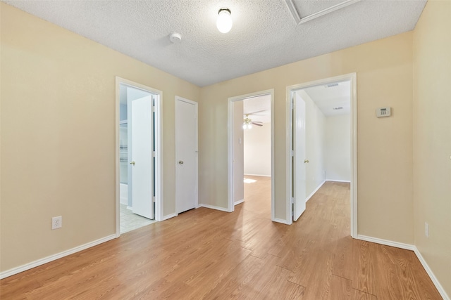 spare room featuring a textured ceiling and light hardwood / wood-style floors