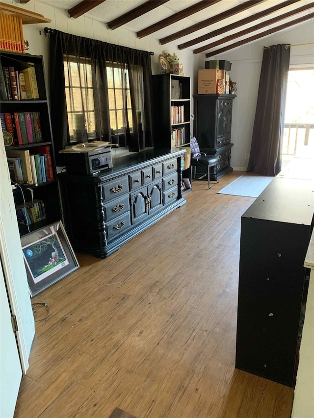 interior space with hardwood / wood-style floors and vaulted ceiling with beams