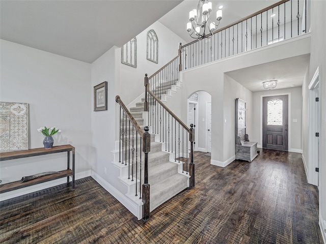 foyer entrance with dark hardwood / wood-style floors, a high ceiling, and a chandelier