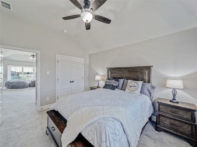 bedroom featuring light carpet, ceiling fan, a closet, and lofted ceiling